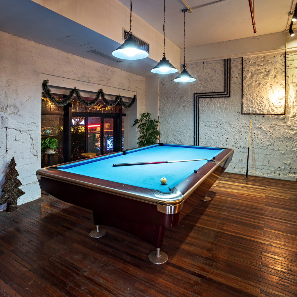 A billiards table in a cool, cozy den or man cave. 